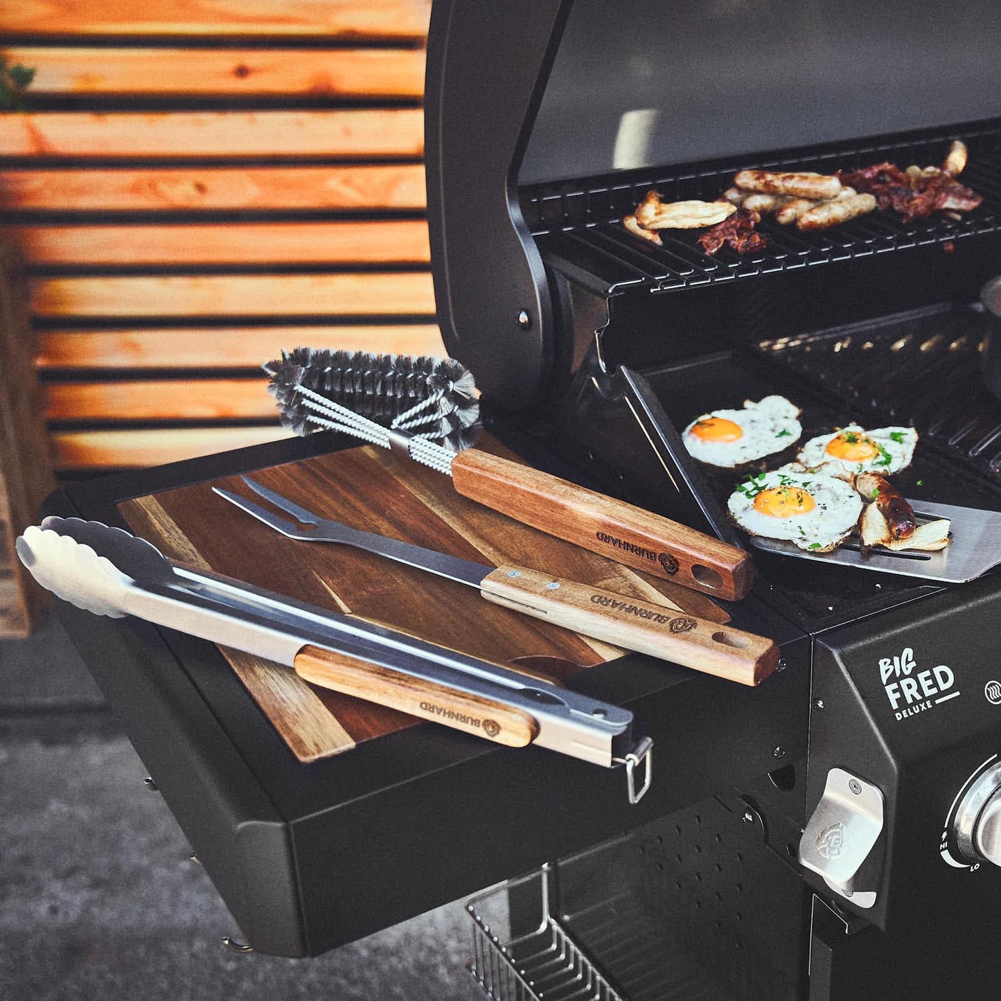 BURNHARD Grillbesteck-Set (4-tlg., 42 cm) aus Edelstahl und Akazienholz – bestehend aus Zange, Wender, Fleischgabel und Grillbürste. Extra lange Holzgriffe mit Aufhänge-Ösen für sicheres und stilvolles Grillen. Robustes Zubehör für echte BBQ-Fans.